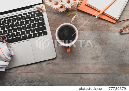 Freelance workspace with laptop computer, notebook, coffee cup and headphone on wooden table. Freelance workspace with laptop computer, notebook, coffee cup and headphone on wooden table. 77789879