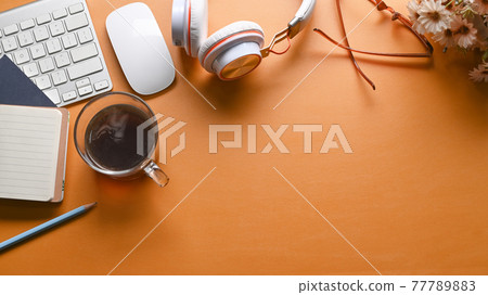 Top view stylish workspace with headphone, notebook, houseplant and coffee cup on yellow leather. 77789883