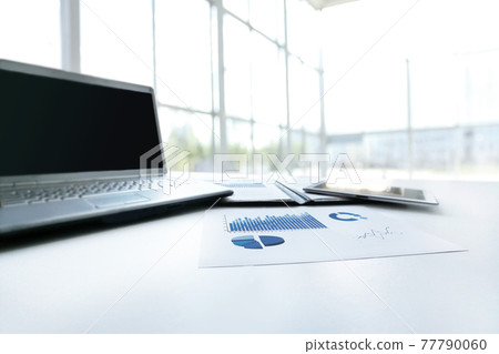 Financial chart, laptop and tablet on the workplace of a businessman 77790060