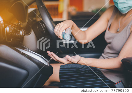 Woman using hand sanitizer gel before driving a car,Preventive measures against coronavirus,Covid-19 pandemic Woman using hand sanitizer gel before driving a car,Preventive measures against coronavirus,Covid-19 pandemic 77790500