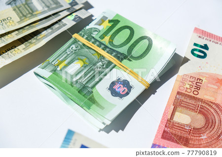 Close up of Euro money roll. Euro banknote set cash money - EU currency. Rolled with rubber euro notes. Banknotes stacked on each other in different positions Close up of Euro money roll. Euro banknote set cash money - EU currency. Rolled with rubber euro notes. Banknotes stacked on each other in different positions 77790819