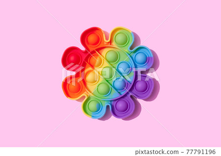 Rainbow pop it fidget toy on pink background. Push bubble fidget sensory toy - washable and reusable stress relief toy. Antistress toy for children or adult. Mental health concept, selective focus 77791196