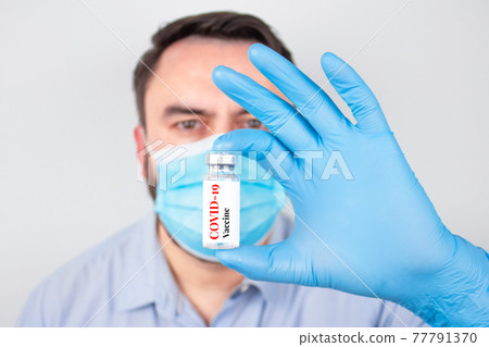 Doctor or scientist holding COVID-19 vaccine - coronavirus prevention, global vaccination concept. Selective focus Doctor or scientist holding COVID-19 vaccine - coronavirus prevention, global vaccination concept. Selective focus 77791370