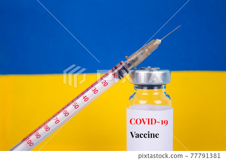 COVID-19 vaccine vial against Ukrainian flag on blue background with copy space for text - coronavirus vaccine doses, vaccination in Ukraine concept. Selective focus COVID-19 vaccine vial against Ukrainian flag on blue background with copy space for text - coronavirus vaccine doses, vaccination in Ukraine concept. Selective focus 77791381