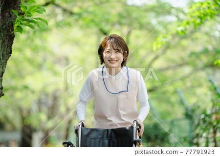 Young woman fresh green caregiver wheelchair Young woman fresh green caregiver wheelchair 77791923