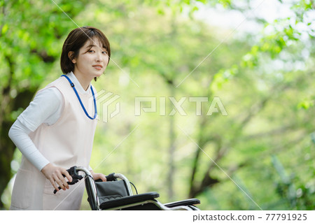 Young woman fresh green caregiver wheelchair Young woman fresh green caregiver wheelchair 77791925