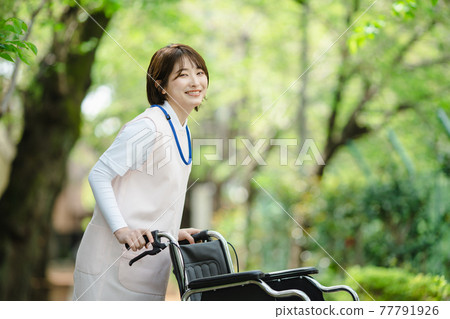 Young woman fresh green caregiver wheelchair 77791926