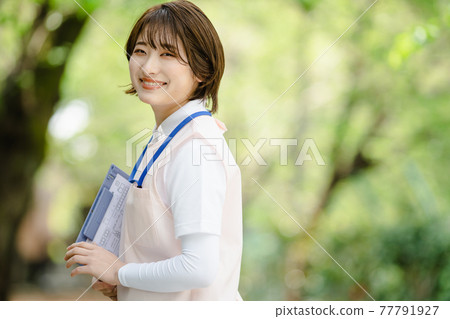 年輕女子新鮮綠色照顧者 77791927