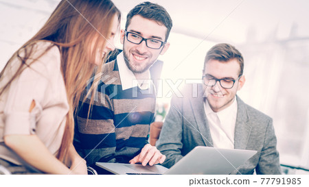 friendly business team working on laptop and discussing business matters friendly business team working on laptop and discussing business matters 77791985