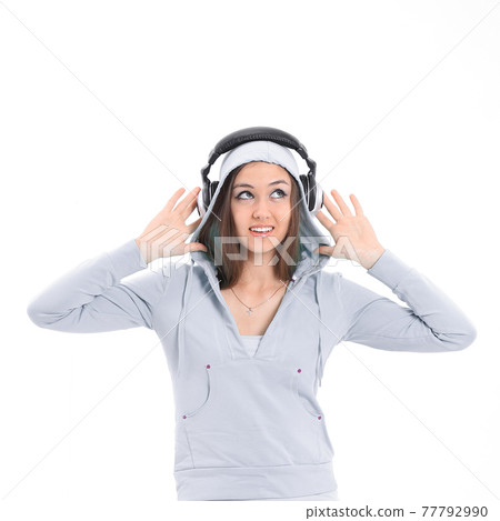 young woman listening to music with headphones 77792990