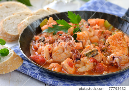 Delicious seafood ragout with spicy tomato sauce in an iron frying pan 77793682
