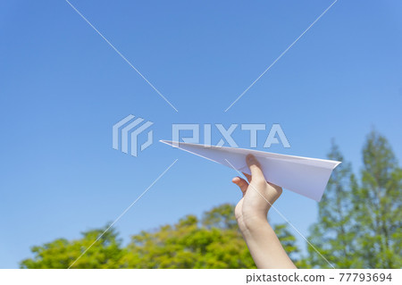 A child flying a paper plane in nature A child flying a paper plane in nature 77793694