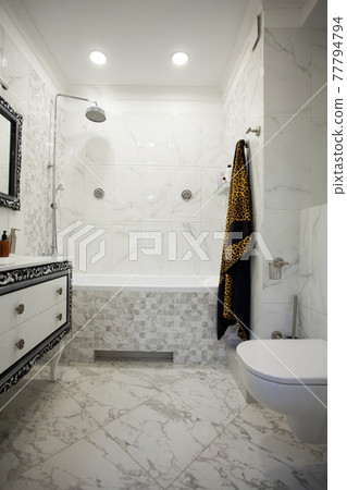 Modern bathroom with marble tiles, luxurius wardrobe and white toilet 77794794