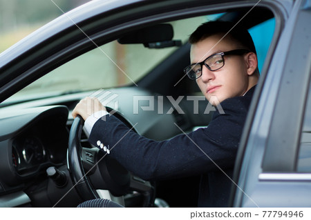 close up.successful young businessman sitting behind the wheel of a car. close up.successful young businessman sitting behind the wheel of a car. 77794946