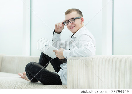 smiling guy looking through media files on his tablet smiling guy looking through media files on his tablet 77794949