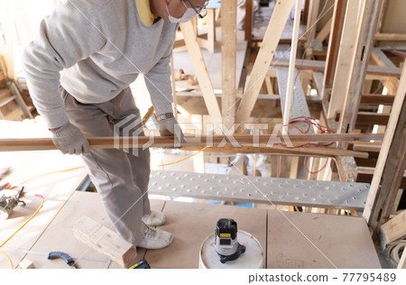 Carpenter working at a construction site Carpenter working at a construction site 77795489