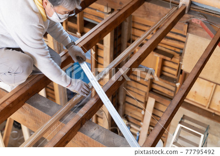 Carpenter working at a construction site Wood bonding 77795492