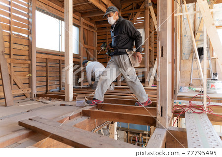 Carpenter working at a construction site 77795495
