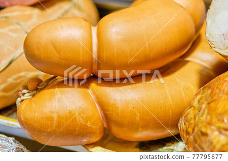 Meat sausages on a store counter. 77795877