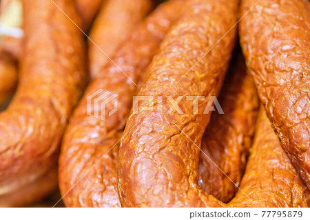 Meat sausages on a store counter. 77795879