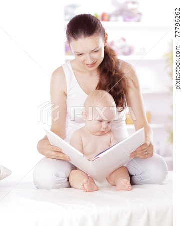 charming mom reading a book to her baby charming mom reading a book to her baby 77796262