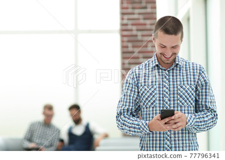 young man reading a SMS on his smartphone 77796341