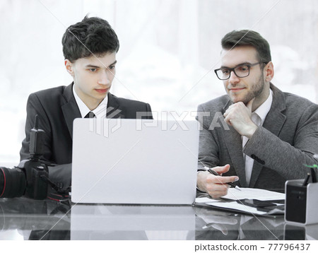 qualified photographers discuss photos to upload files on a laptop . 77796437