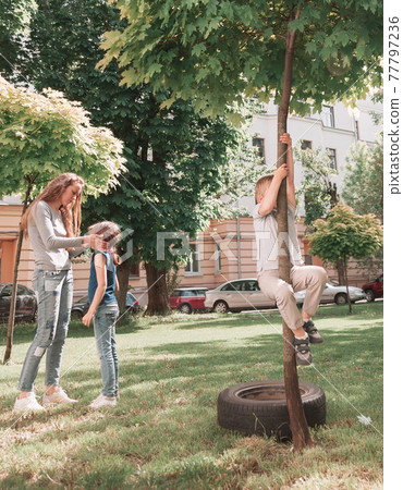 mother and children playing in the city yard. 77797236