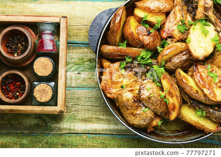 Chicken baked with potatoes in a iron cast pan Chicken baked with potatoes in a iron cast pan 77797271
