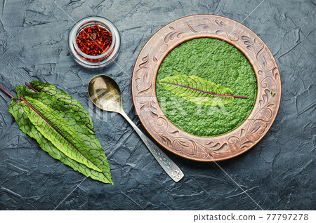 Green soup with sorrel in rustic plate 77797278