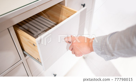 Male hand opening drawer on wooden cabinet Male hand opening drawer on wooden cabinet 77798015