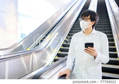 Asian man wearing mask at skytrain station Asian man wearing mask at skytrain station 77798022