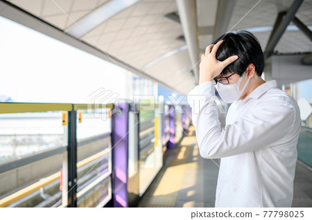Asian man wearing mask at skytrain station Asian man wearing mask at skytrain station 77798025