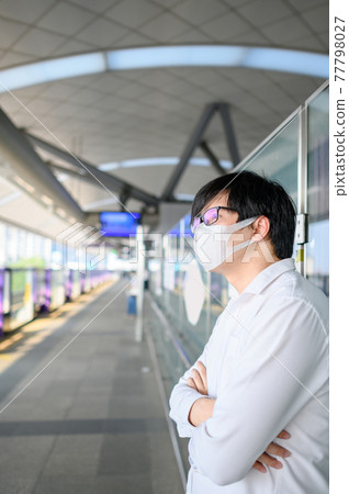 Asian man wearing mask at skytrain station Asian man wearing mask at skytrain station 77798027