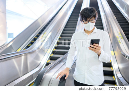 Asian man wearing mask at skytrain station 77798029