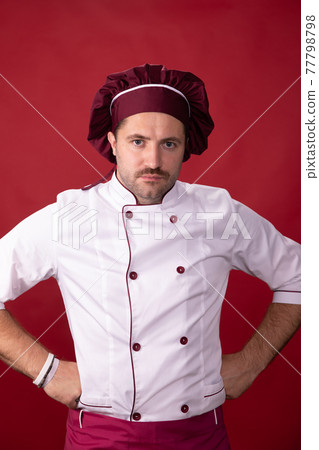 Portrait of serious handsome chef in uniform on isolated red background Portrait of serious handsome chef in uniform on isolated red background 77798798