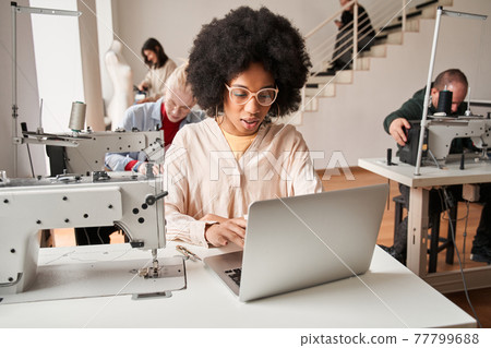 Woman sitting in front of the laptop and chatting with colleagues remotely Woman sitting in front of the laptop and chatting with colleagues remotely 77799688