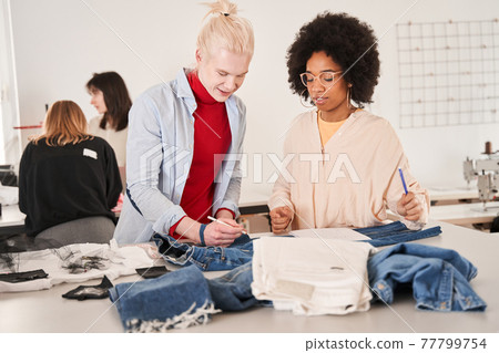 Man listening ideas of his multiracial female colleague while working Man listening ideas of his multiracial female colleague while working 77799754