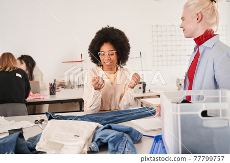 Man listening ideas of his multiracial female colleague while working Man listening ideas of his multiracial female colleague while working 77799757