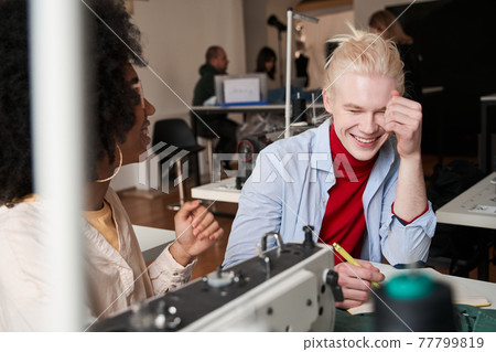 Multiracial female stitching fabric on professional manufacturing machine at workplace Multiracial female stitching fabric on professional manufacturing machine at workplace 77799819