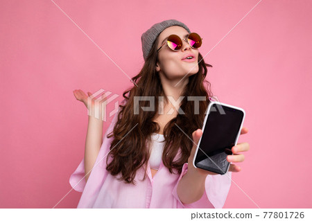 Positive attractive young brunette female person wearing stylish pink shirt grey hat and colourful 77801726