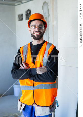 Young handsome worker smiling and looking at the camera Young handsome worker smiling and looking at the camera 77801777
