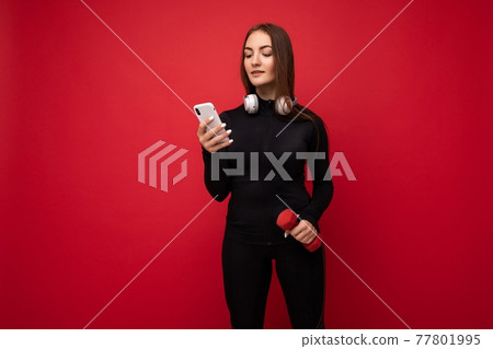 Photo of sexy attractive positive young brunette woman wearing black sport clothes white headphones Photo of sexy attractive positive young brunette woman wearing black sport clothes white headphones 77801995