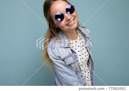 Attractive smiling happy young blonde woman wearing everyday stylish clothes and modern sunglasses Attractive smiling happy young blonde woman wearing everyday stylish clothes and modern sunglasses 77802001