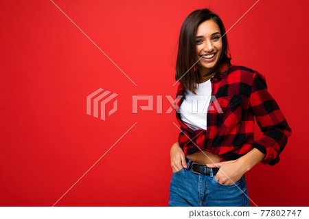 Portrait of positive cheerful smiling young brunette woman in casual white t-shirt, stylish red 77802747