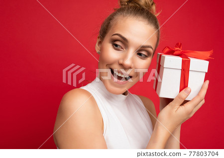 Portrait photo shot of attractive happy amazed young blonde woman isolated over red background wall 77803704