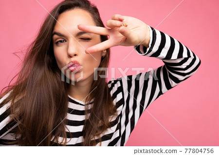 Photo of young positive happy beautiful brunette woman with sincere emotions wearing casual striped Photo of young positive happy beautiful brunette woman with sincere emotions wearing casual striped 77804756