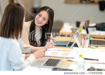 兩個女人一邊看房子的平面圖一邊開會的商業場景 兩個女人一邊看房子的平面圖一邊開會的商業場景 77805098