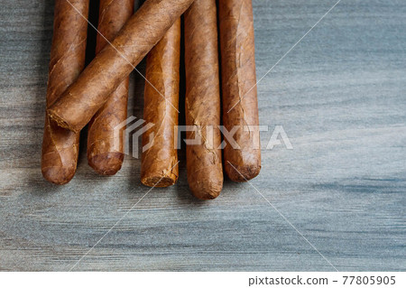 Close view of cigars on the wooden background Close view of cigars on the wooden background 77805905