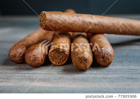 Close view of cigars on the wooden background Close view of cigars on the wooden background 77805906